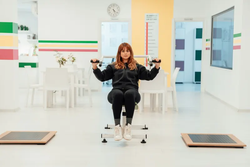 Una paciente hace ejercicio en una máquina de una sala de rehabilitación